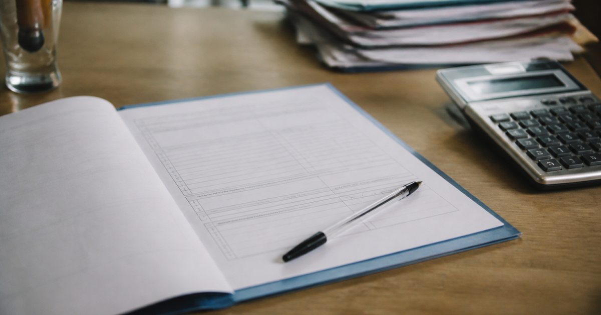 Formulaire administratif ouvert sur bureau avec stylo et calculatrice