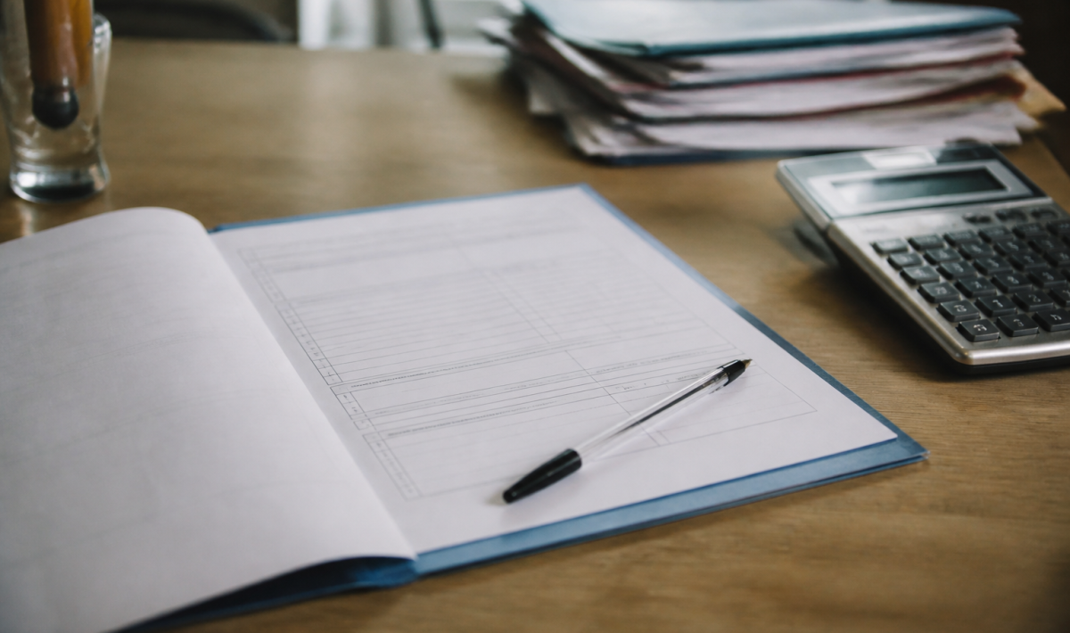 Formulaire administratif ouvert sur bureau avec stylo et calculatrice