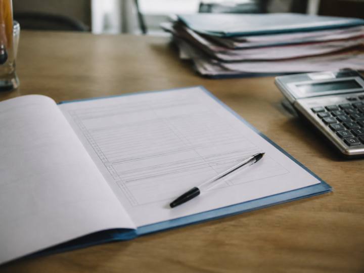 Formulaire administratif ouvert sur bureau avec stylo et calculatrice