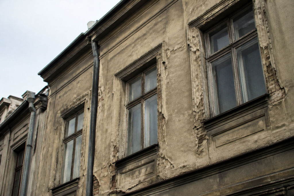 Immeuble ancien avec facade deterioree et fenetre simple vitrage