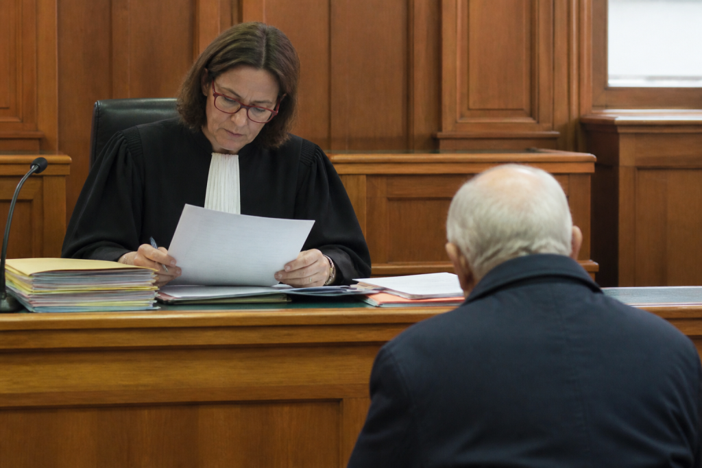 Juge examinant dossier loyer impayé devant locataire âgé