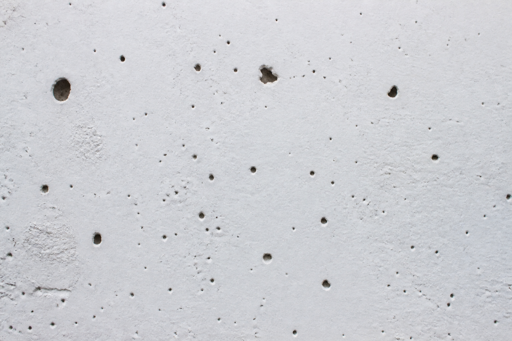 Mur blanc avec trous de differentes tailles visibles