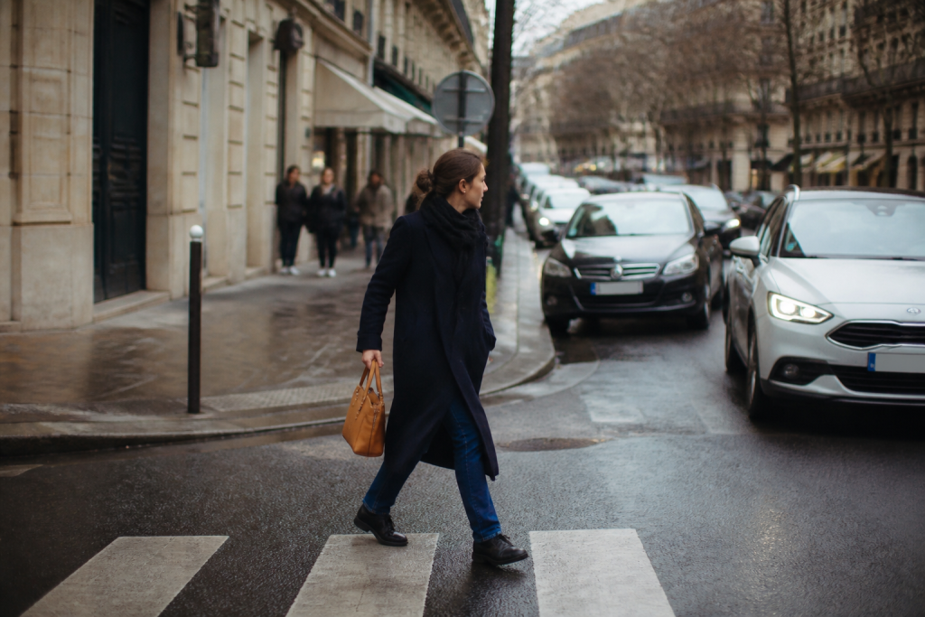 Pieton vigilant traversant rue parisienne animee avec precaution