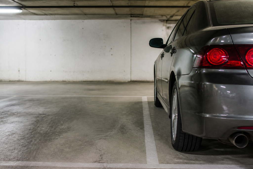 Place de parking souterraine avec voiture stationnée et mesures au sol