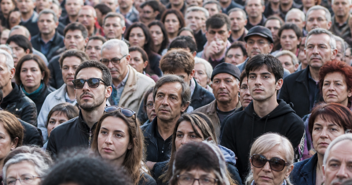Foule dense de personnes debout face à la camera