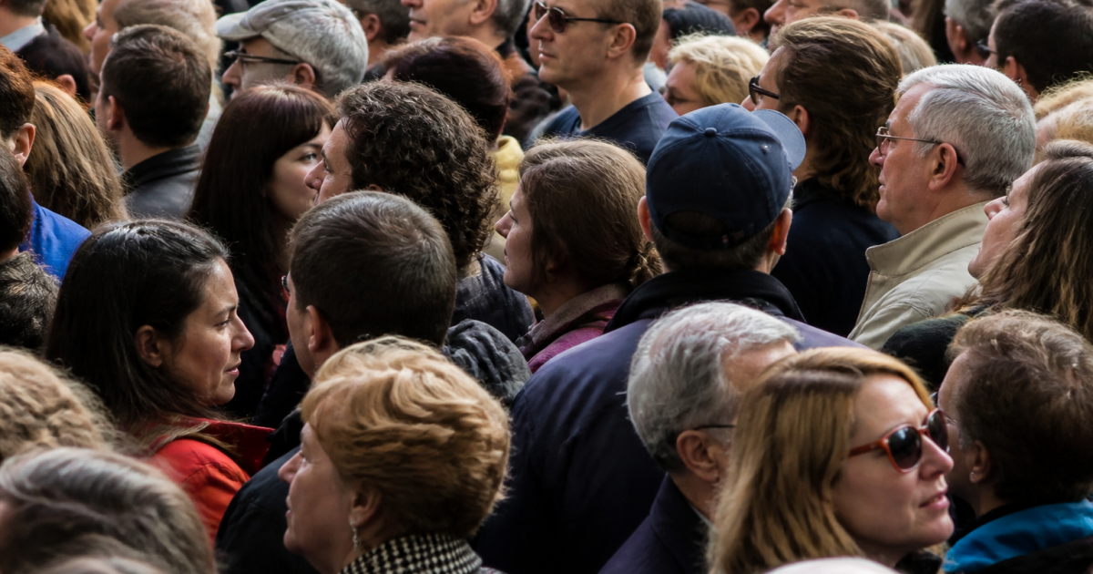 Foule dense de personnes debout côte à côte dans rue urbaine
