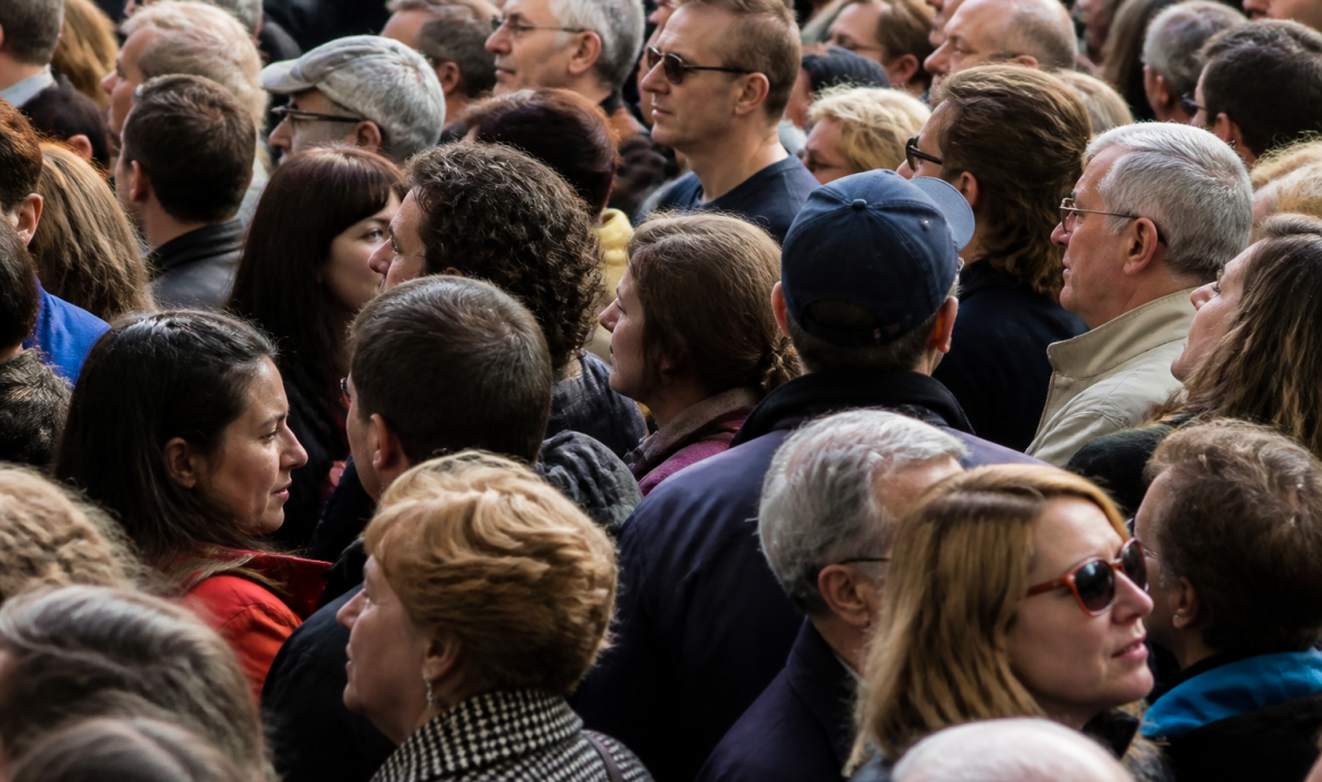 Foule dense de personnes debout côte à côte dans rue urbaine