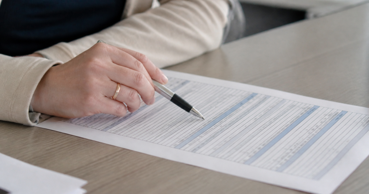 Document administratif sur table avec stylo pointant colonnes chiffres