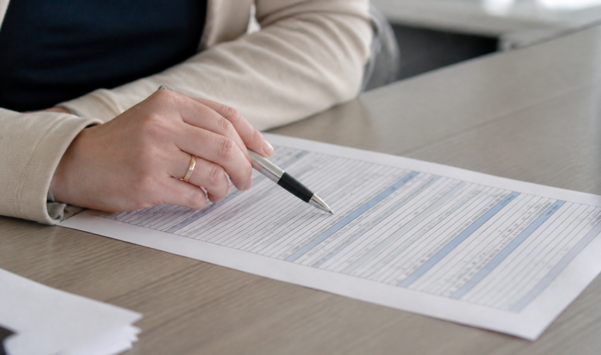 Document administratif sur table avec stylo pointant colonnes chiffres