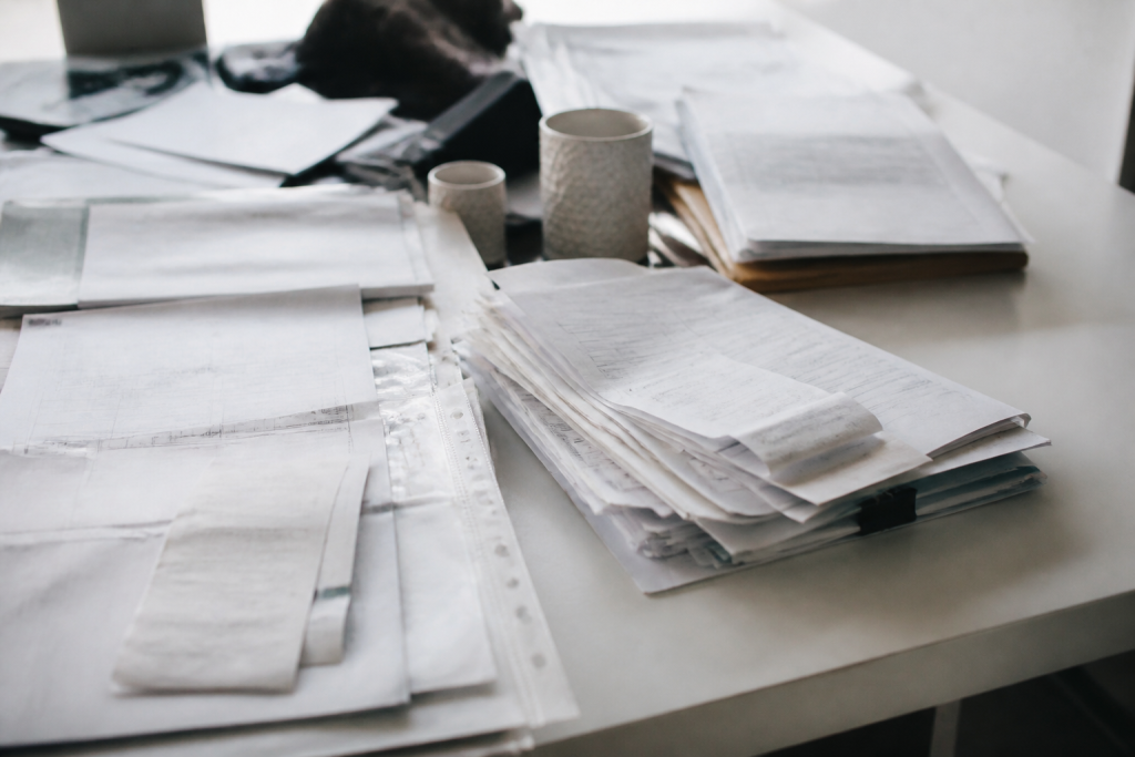 Documents comptables et factures étalés sur bureau blanc