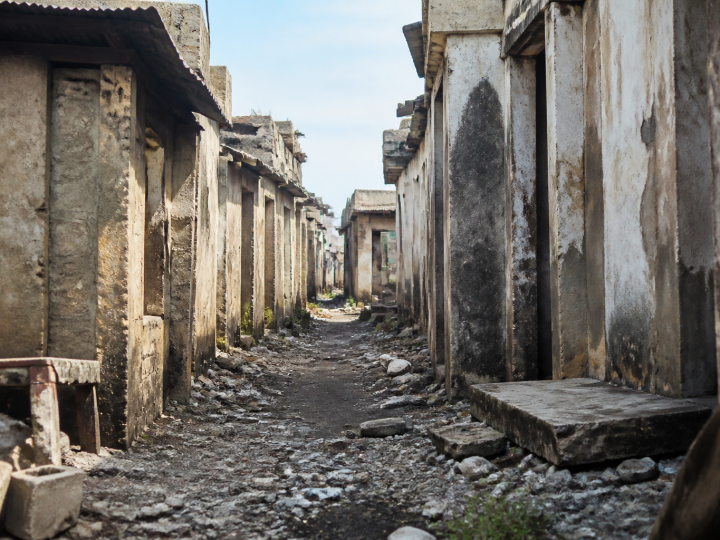 Rue etroite delabree avec batiments abandonnes et detritus au sol