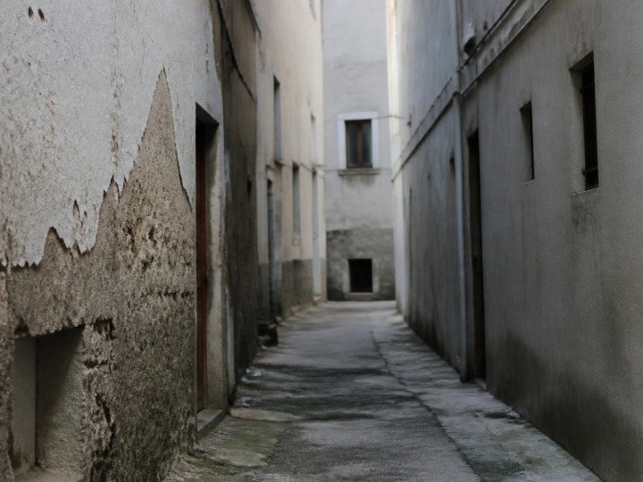 Rue etroite avec immeubles deteriores et facades grises delabrees