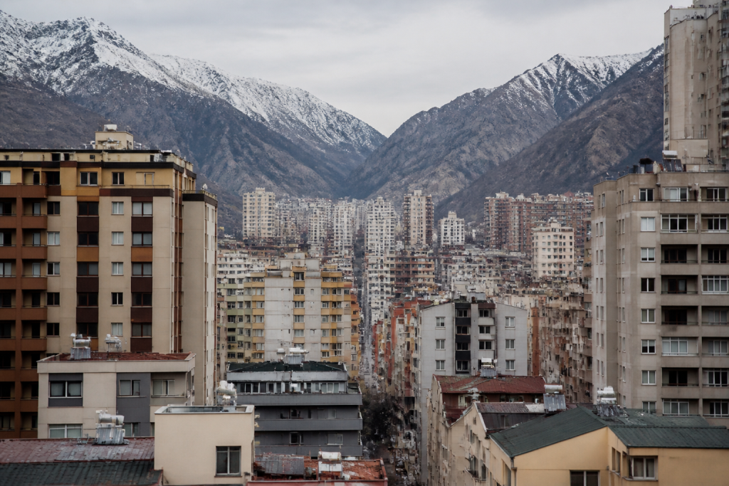 Immeubles serrés entre montagnes enneigées formant vallée urbaine dense